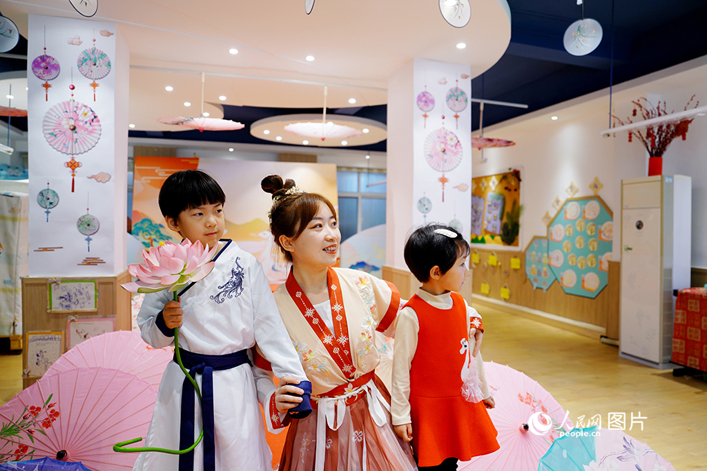 5月30日,济南市历下区甸柳中心幼儿园组织全体幼儿及家长,举办“多彩非遗·童心启梦”庆六一主题活动。图为孩子与老师表演汉服走秀。人民网记者 刘祺摄